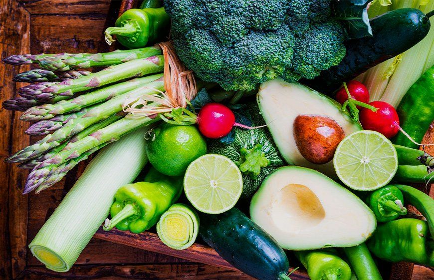 A wooden box filled with variety of vegetables.