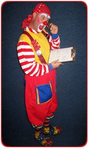 A clown talking on a cell phone while holding a clipboard