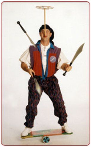 A man is standing on a skateboard with a plate on his head