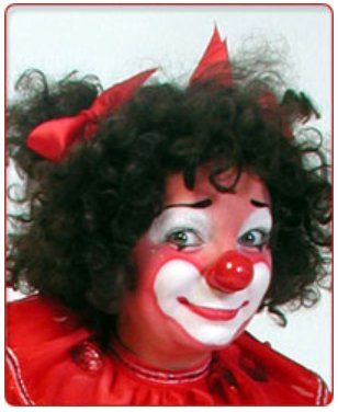A woman dressed as a clown with a red bow in her hair
