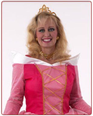 A woman in a pink dress and tiara smiles for the camera