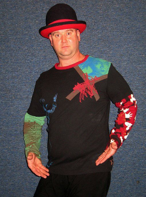 A man wearing a hat and a sweater with a cross on it