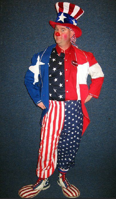 A clown in an uncle sam costume is standing with his hands in his pockets