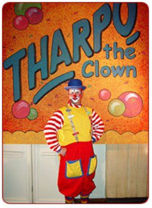 A clown stands in front of a sign that says tharpu the clown
