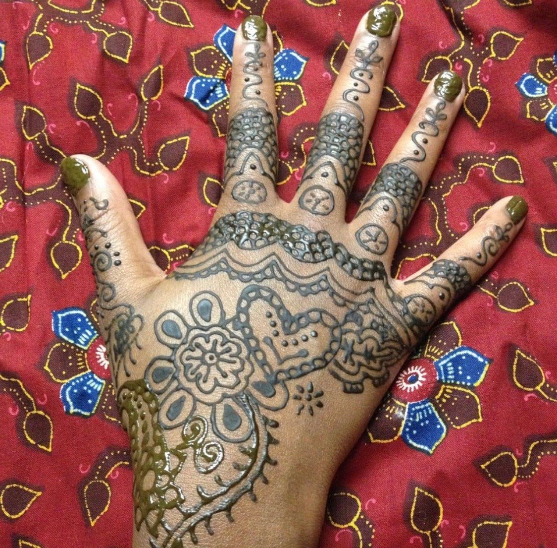 A woman 's hand with a henna design on it