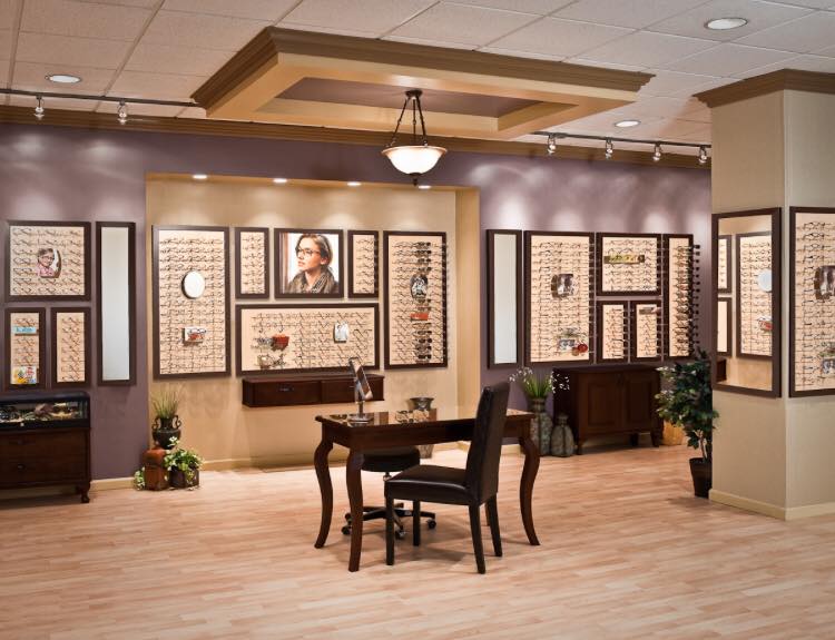 Art gallery interior with framed wall displays, a central table, and warm beige lighting