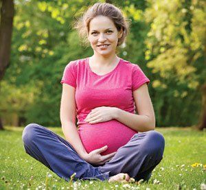 pregnant woman sitting on grass