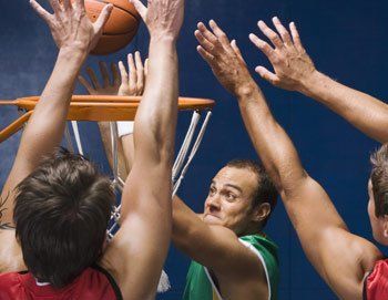 3 men playing basketball