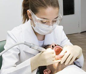 dentist cleaning patient teeth