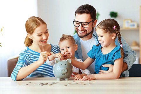 A family is putting coins into a piggy bank.