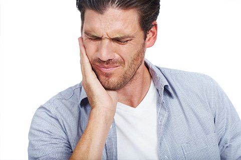 A man is holding his face in pain because of a toothache.