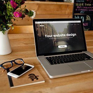 A laptop is open to a page that says your website design