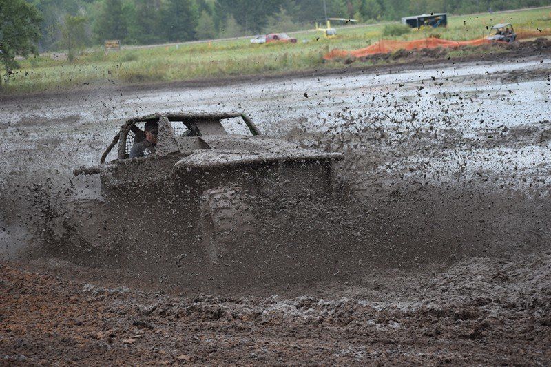 Off-road truck kicking up mud in a muddy track, splashing across the frame