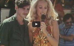 A woman is holding a microphone while standing next to a man.