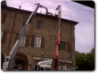 due macchinari sollevano materiali edili su tetto abitazione