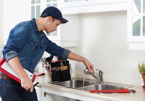 Kitchens — Plumber with cap checking the sink in South Yarmouth, MA