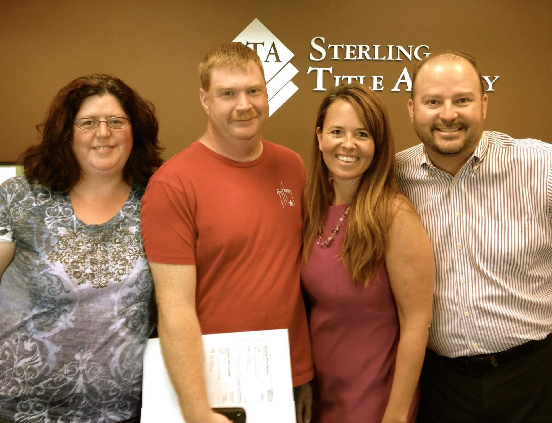 A group of people posing in front of sterling title agency