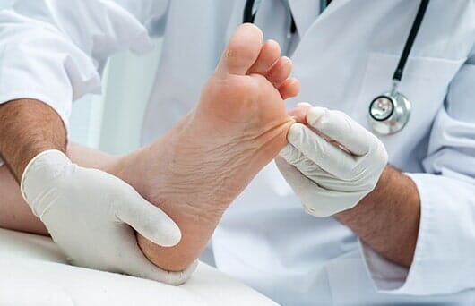 Doctor Checking Foot — Podiatry Clinic in Eugene, OR Doctor Checking Foot — Podiatry Clinic in Eugene, OR