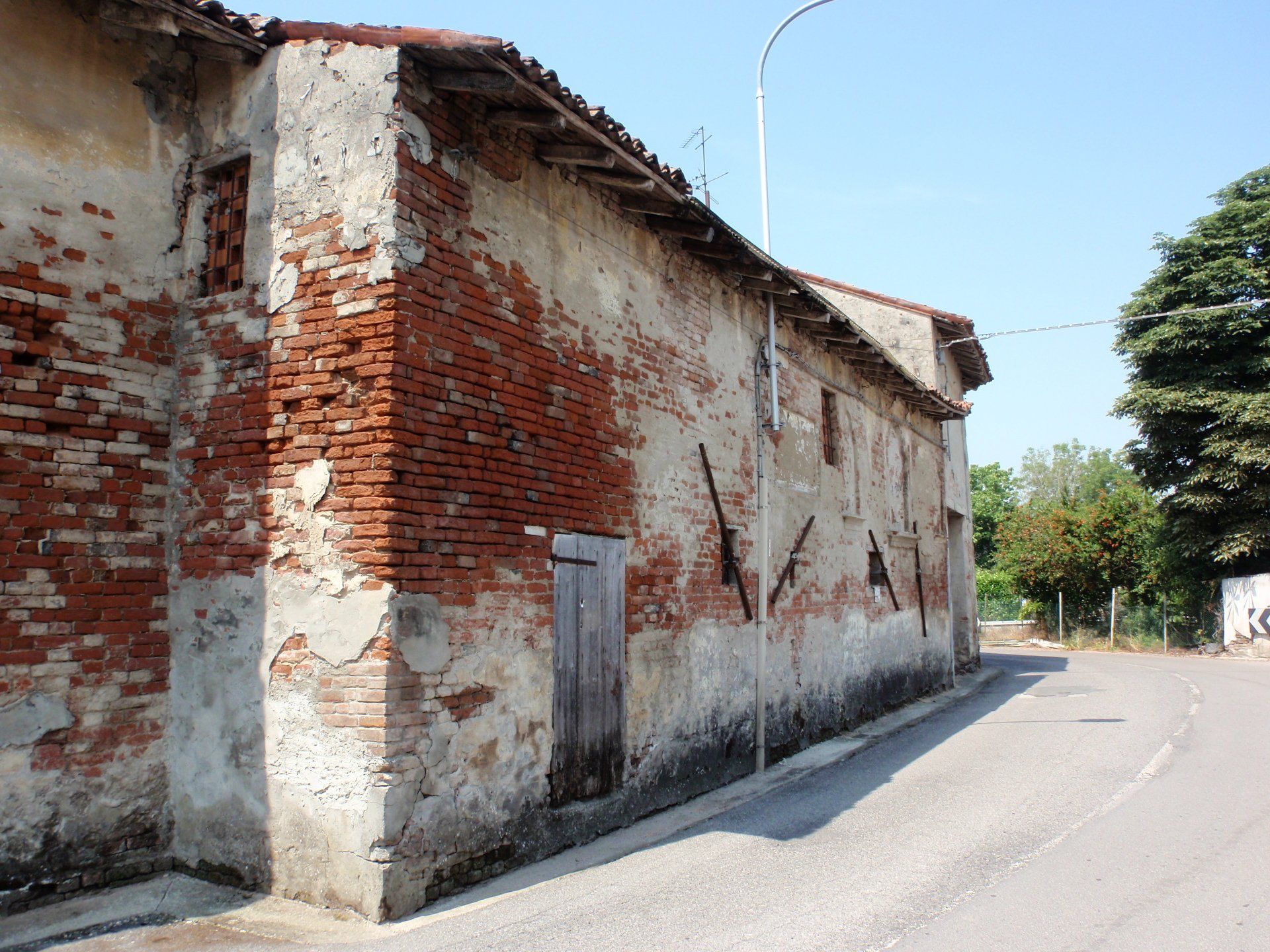 North elevation with a large portion of masonry where there is a lack of plaster and mortar joints.