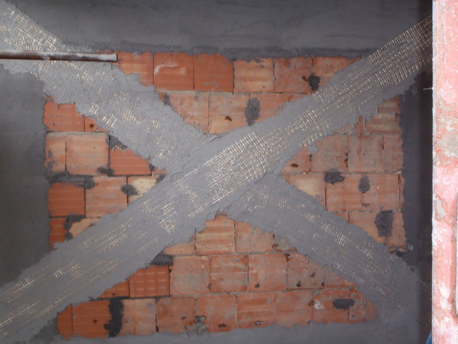reinforcement in masonry partition with laying of fibers FRCM system
