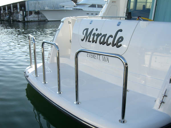 A boat with three staple rails by Tanner Manufacturing installed on the swim platform.