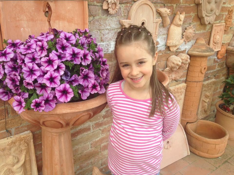 vaso in terracotta con fiori e una bambina