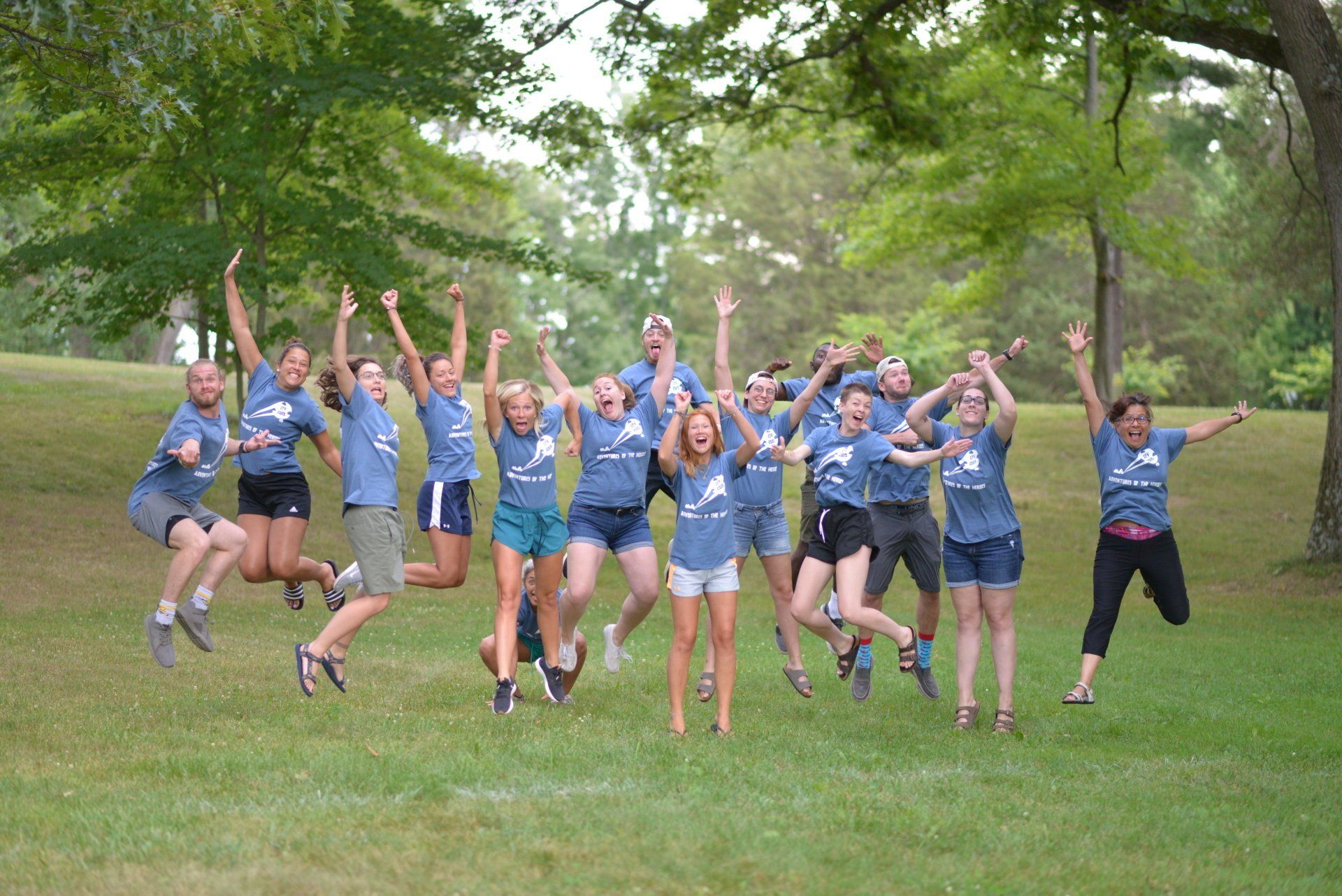 A group of people are jumping in the air in a park.