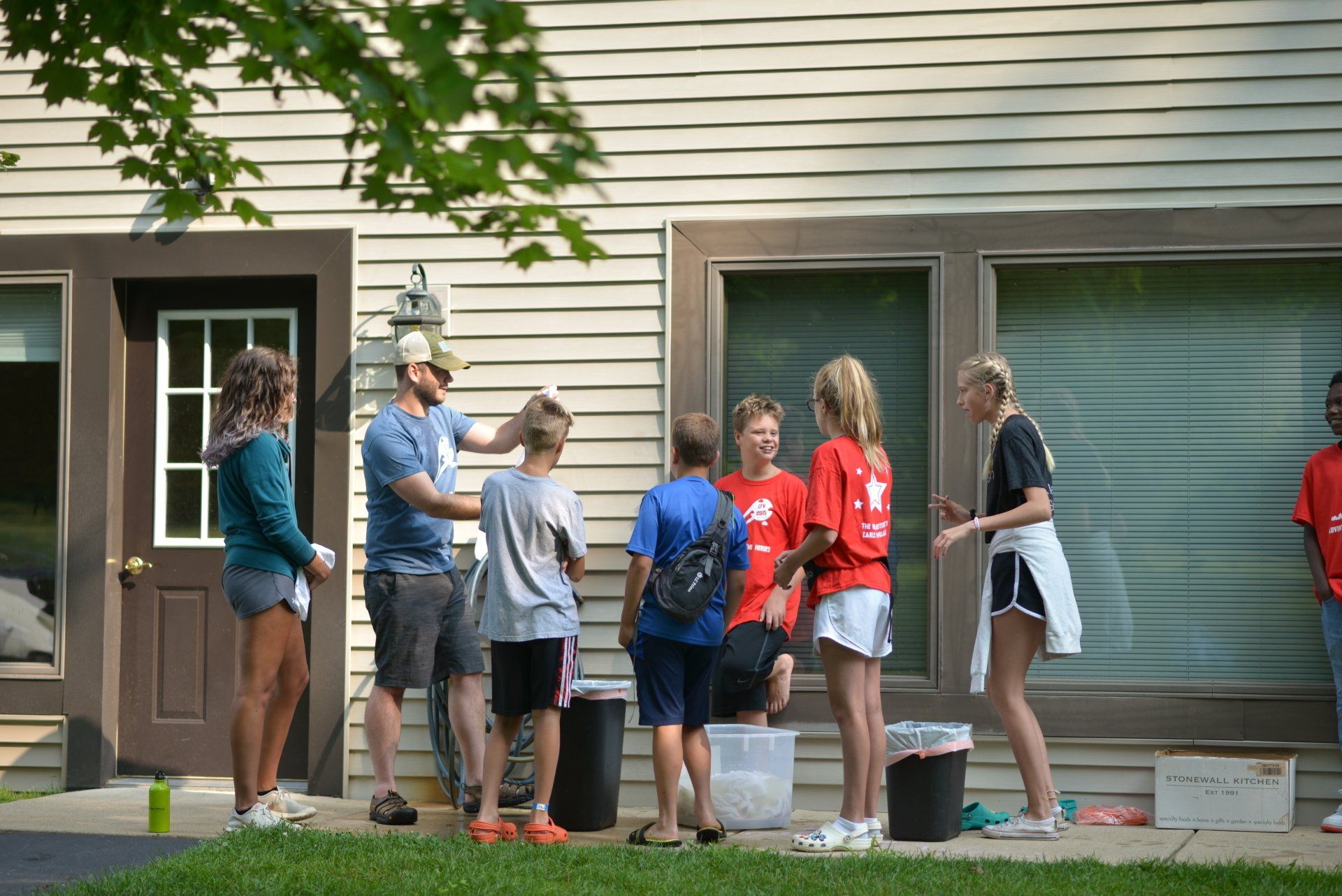 A group of people are standing in front of a house.
