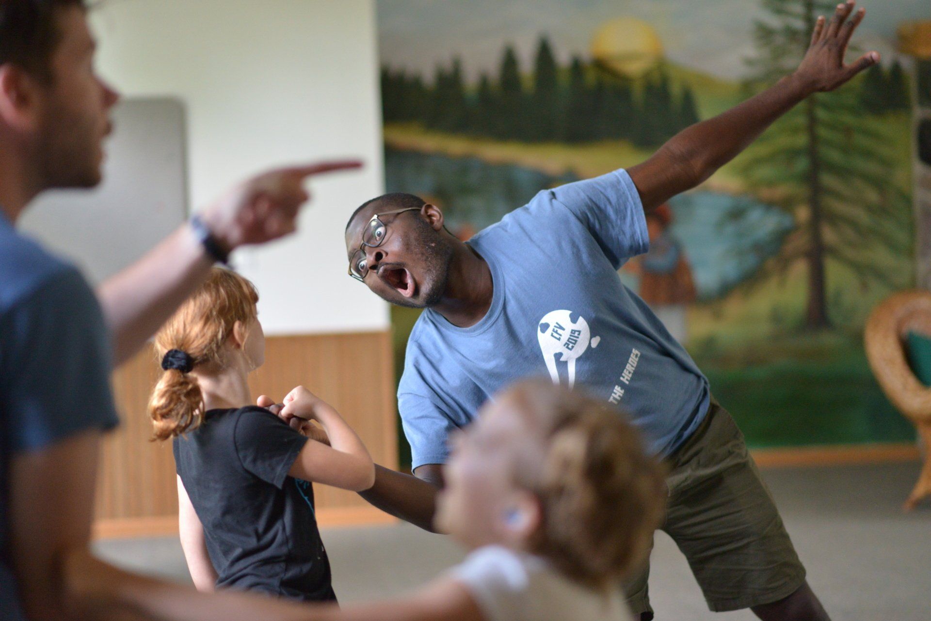 A group of people are standing around a man in a blue shirt.