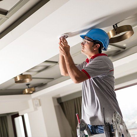 Man Installing Smoke Detector — Valley Cottage, NY — Inter County Alarm Systems Man Installing Smoke Detector — Valley Cottage, NY — Inter County Alarm Systems