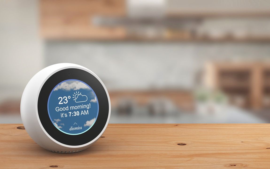 A clock on a wooden table shows the temperature is 23 degrees