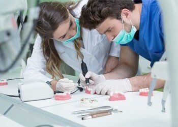 Male and Female Prosthodontist Working on Dentures — Prosthodontics in Beaumont, TX Male and Female Prosthodontist Working on Dentures — Prosthodontics in Beaumont, TX