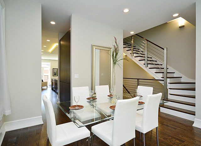 Dining area with modern furniture and a modern staircase leading up to the top floor