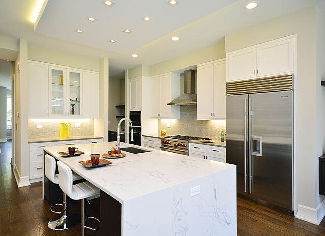 Gourmet kitchen with large stainless steel fridge and marble kitchen island