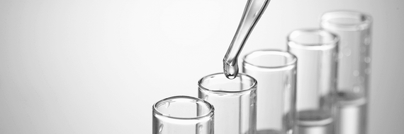 Mit einer Pipette wird Flüssigkeit in ein Reagenzglas gegossen.