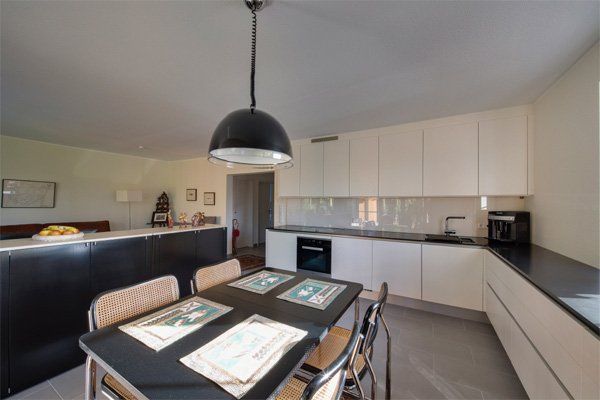 Eine Küche mit Tisch und Stühlen und einer von der Decke hängenden Lampe