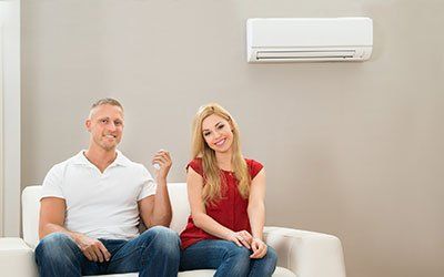 Couple On Sofa Using Air Conditioner - HVAC Contractors in Lebanon, MO Couple On Sofa Using Air Conditioner - HVAC Contractors in Lebanon, MO