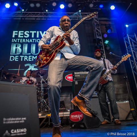 Mr. Sipp playing guitar on stage at the Tremblant Blues festival