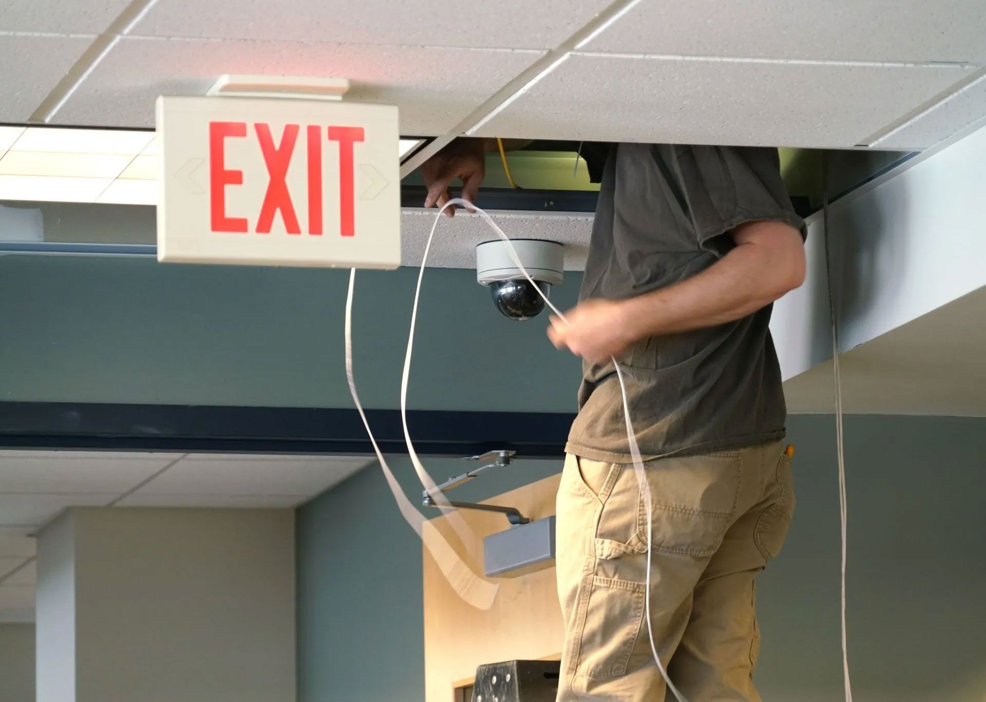 Man Checking Cables in The Ceiling — Houston, TX — Dixie Safe & Lock Service Inc. Man Checking Cables in The Ceiling — Houston, TX — Dixie Safe & Lock Service Inc.