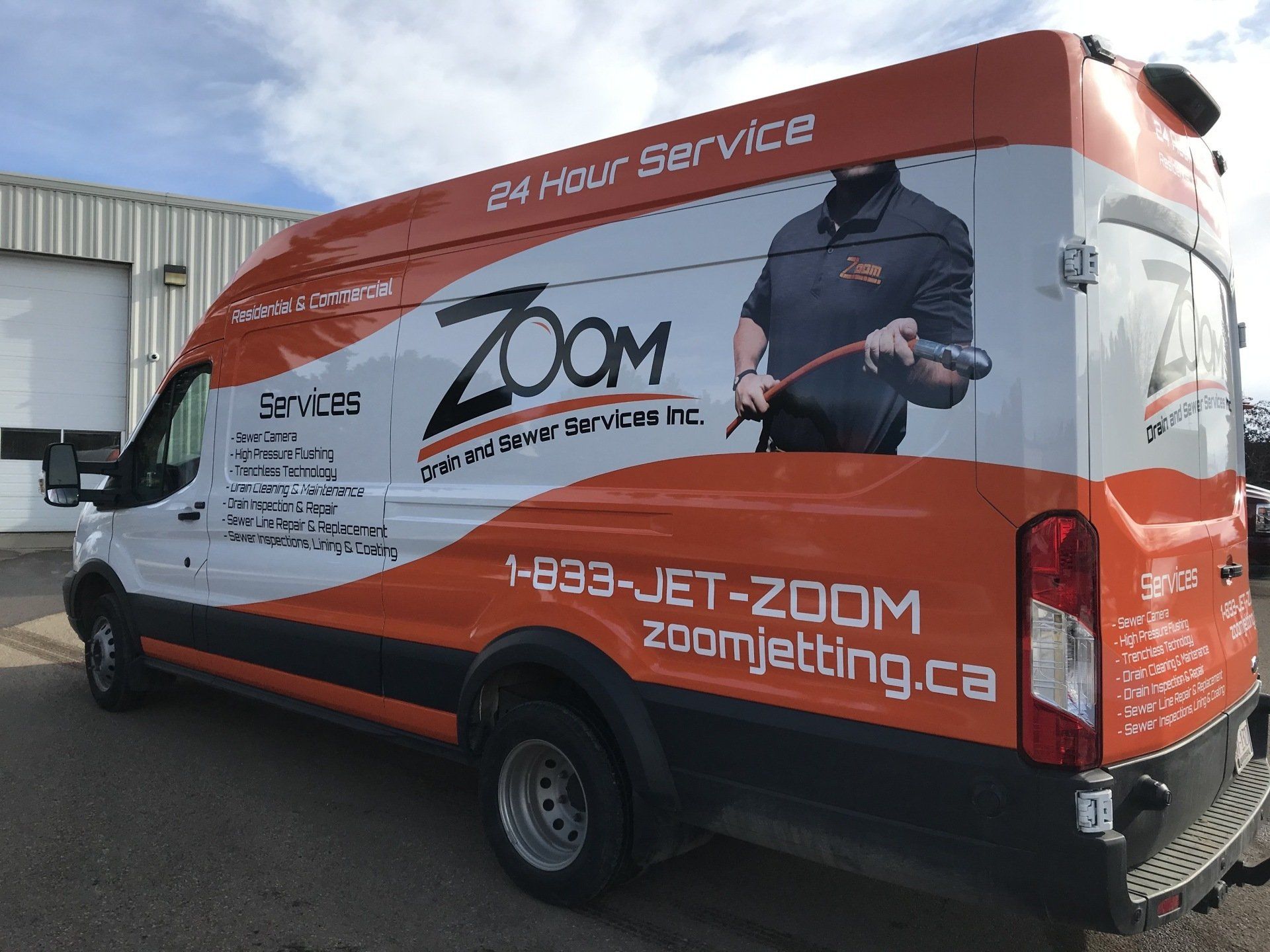 a zoom jetting van is parked in front of a building .