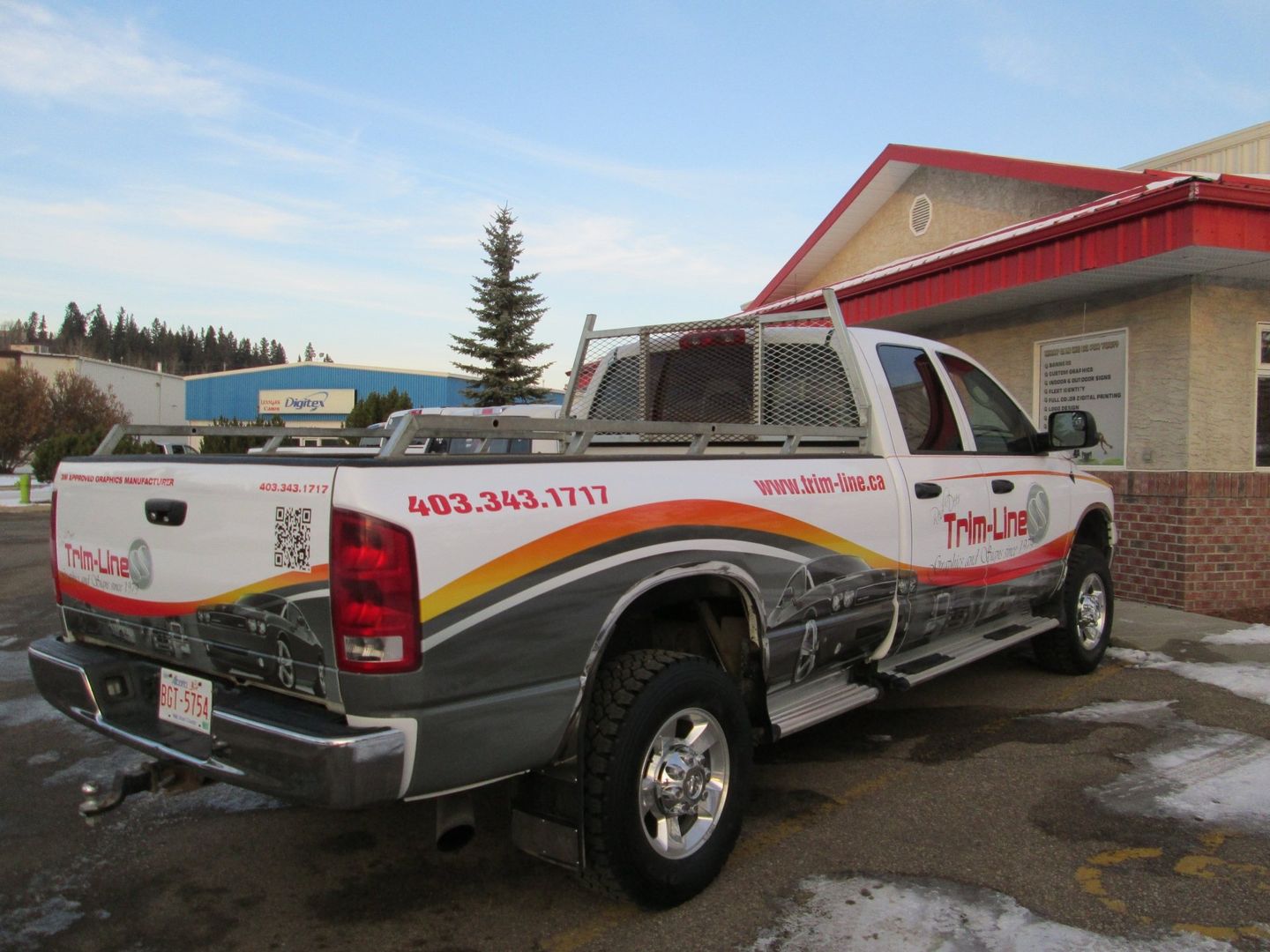a truck is parked in front of a building that says trim-line