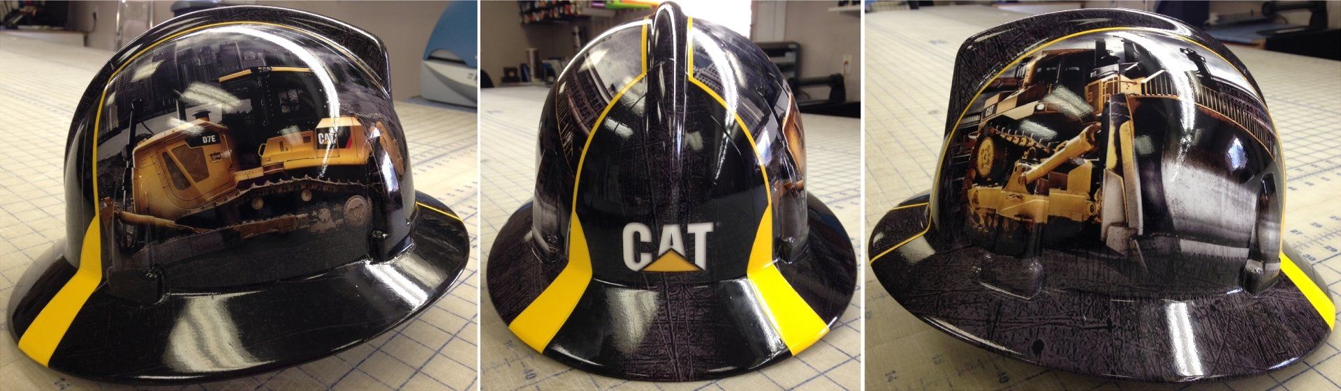 3 construction hats side-by-side with custom decals of construction equipment