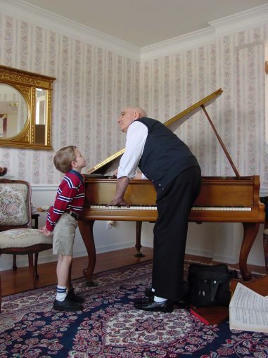 Manny Sr. tunes a piano under the watchful eye of a customer's son. Manny Sr. tunes a piano under the watchful eye of a customer's son.