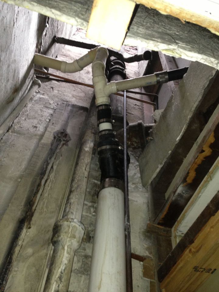A bunch of pipes are hanging from the ceiling of a building.