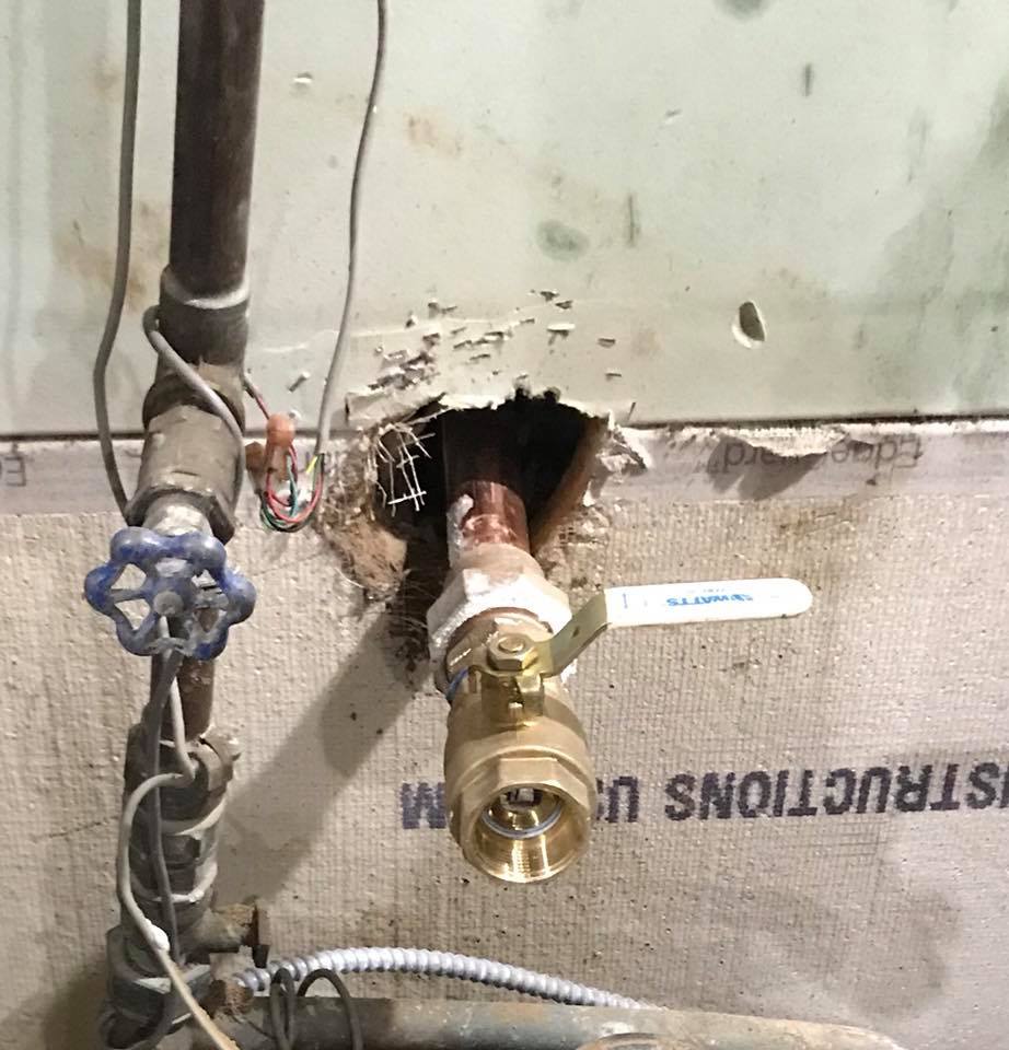 There is a hole in the wall with a valve in it.