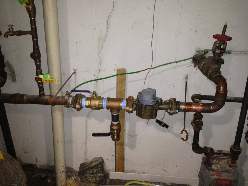 A copper pipe with a water meter attached to it