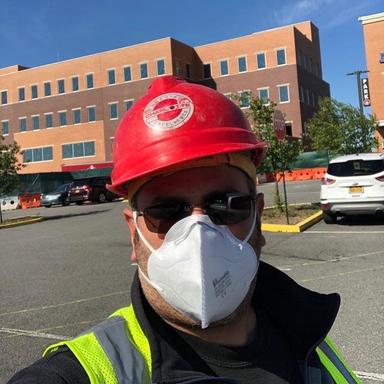 A man wearing a hard hat and a face mask