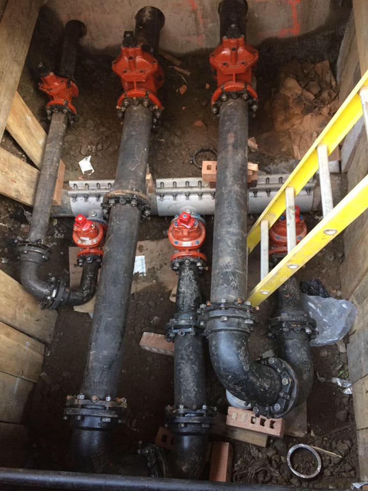 A ladder is sitting next to a bunch of pipes