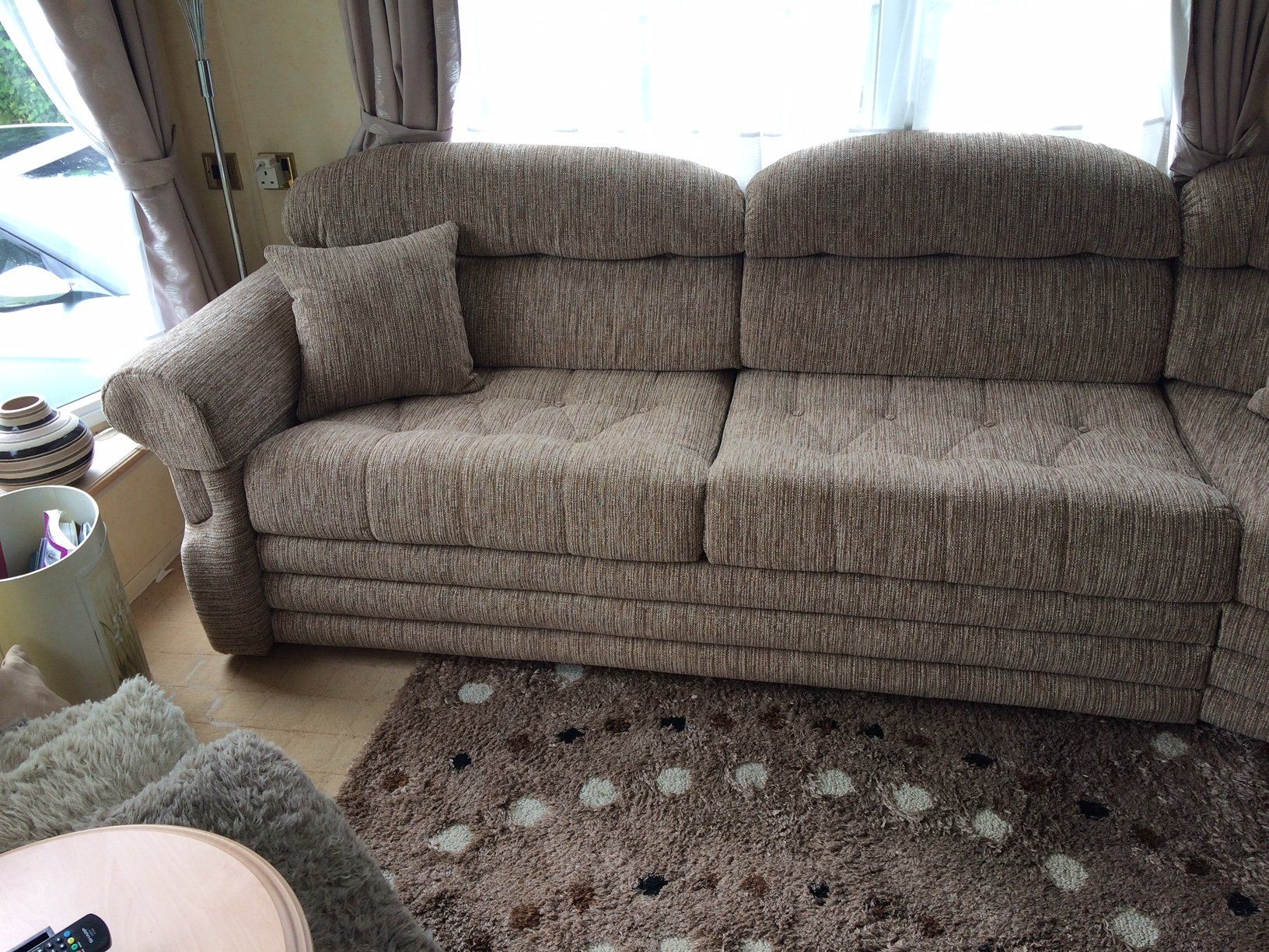 Close up of grey sofa with patterned carpet