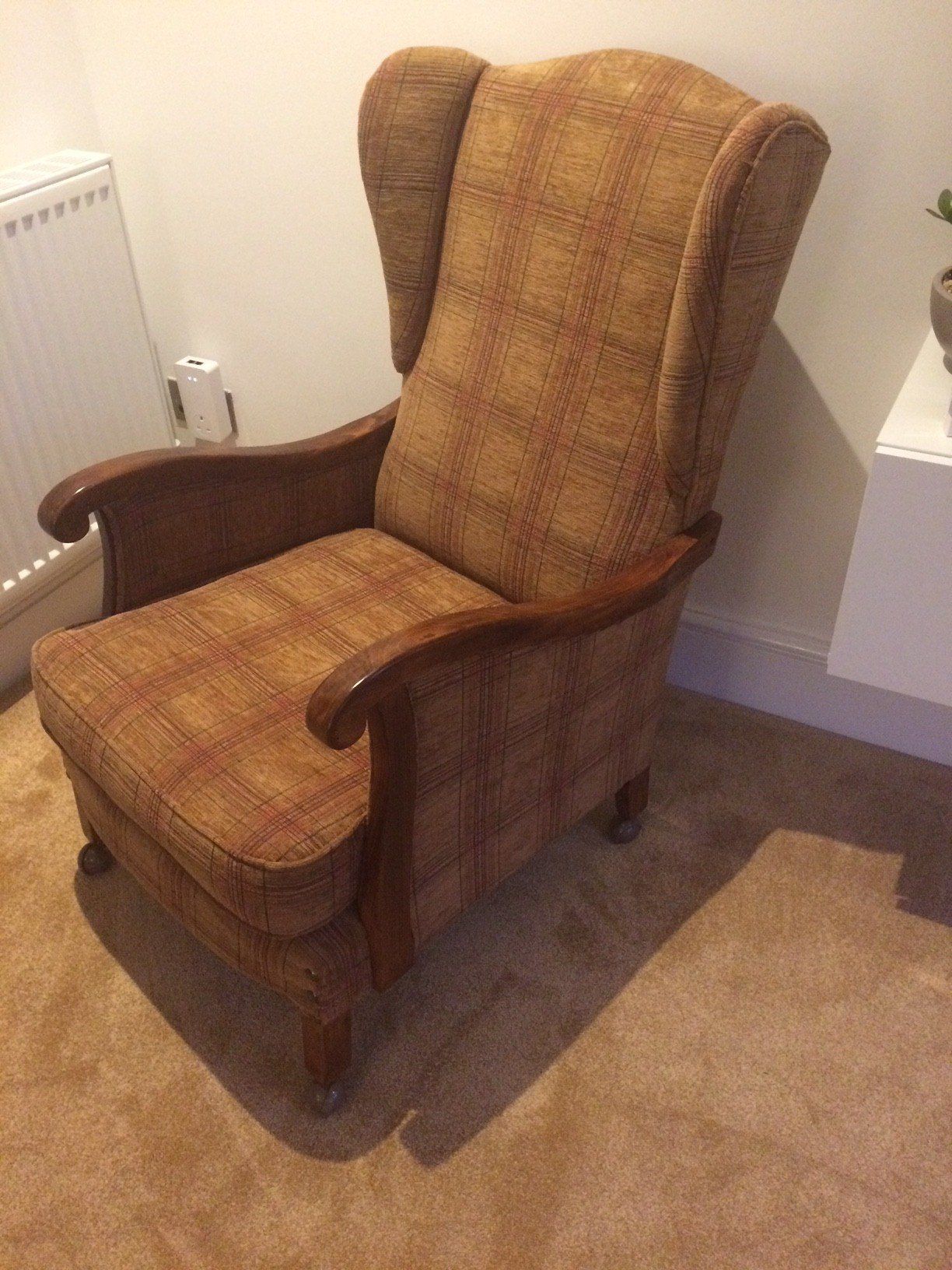 Side angle of chair with brown check upholstery